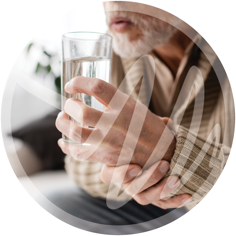 Parkinson’s Disease Symptoms in Seniors » PEMF Recovery Plus Senior man struggling to hold a glass due to hand tremors.