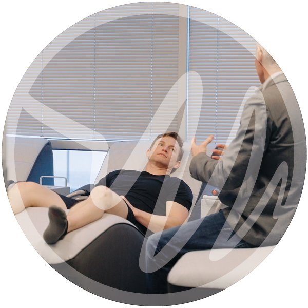 Patient Consultation in a Wellness Recovery Setting » PEMF Recovery Plus Male patient reclining during a wellness consultation with a healthcare professional in a modern clinical setting.